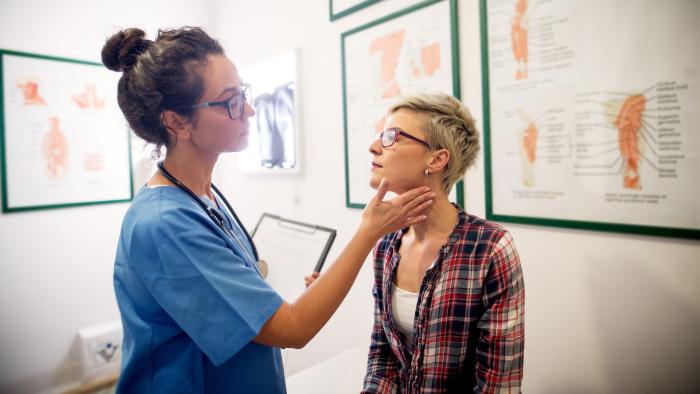 Doctor checks adult woman's lymph nodes.